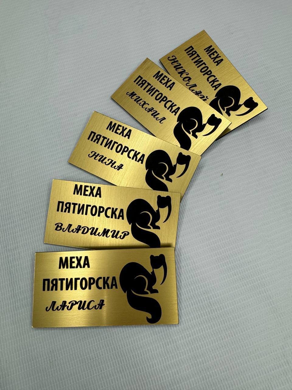 Золотистые бейджи с гравировкой имён и логотипа «Меха Пятигорска»